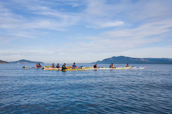 Guided kayak group crossing the distant island