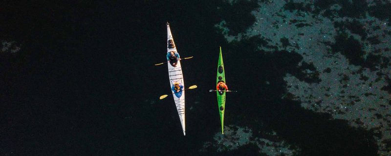 Birds eye view of single and tandem kayak along San Juan Island