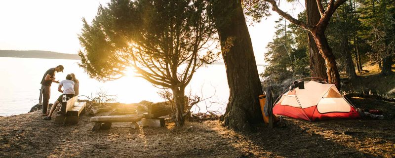 Campers going over kayak tour plan at the beach with kayak guide